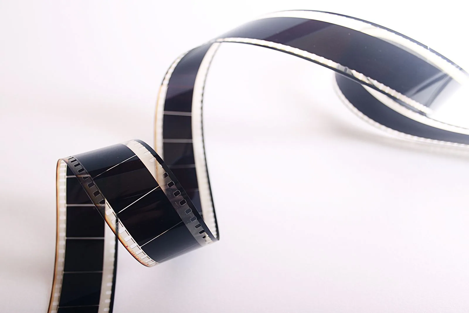 شريط فيلم سينمائي يظهر تتابع الإطارات — رمز لربط المقاطع القصيرة في فيديو طويل
